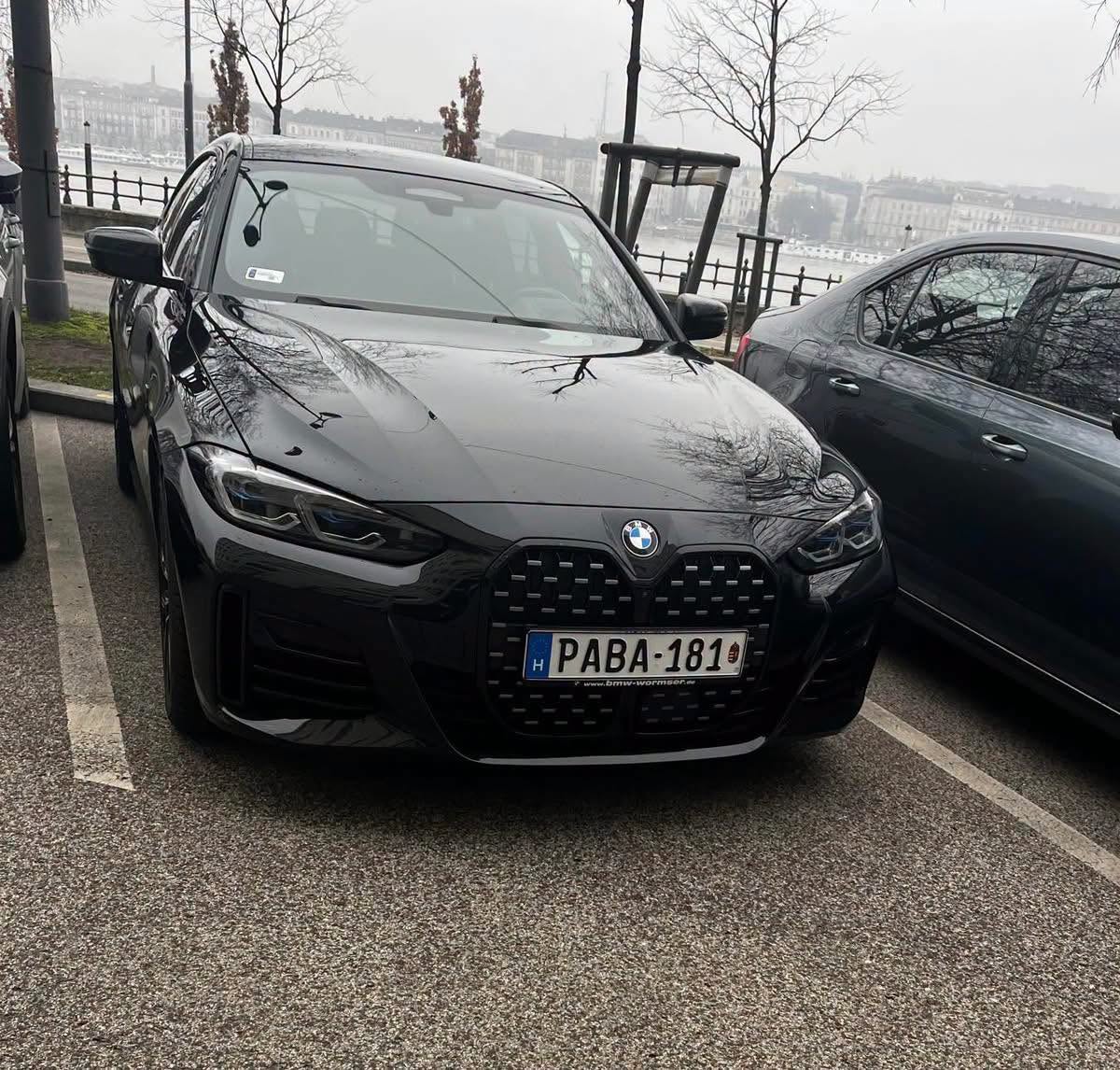 Bánki Erik a Hungast BMW-vel a parlament parkolójában